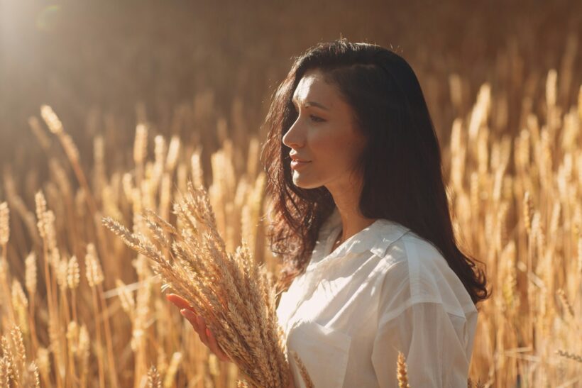 woman in white shirt standing on brown grass field during daytime