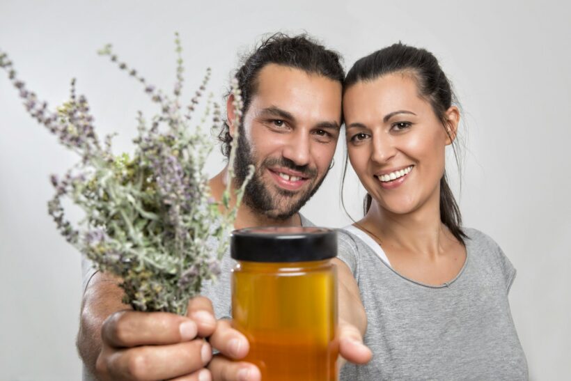 man and woman holding plants